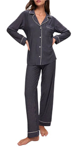 A person wearing the Eberjey Tencel Modal Long PJ Set, featuring a black and white striped design with a button-up long-sleeved top and temperature-regulating, luxurious knit fabric long pants, stands barefoot with hands on hips.