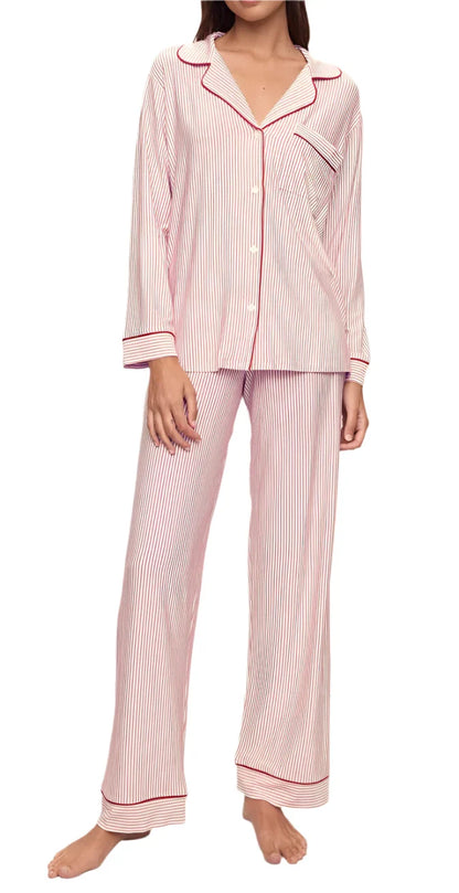 A person wearing the Eberjey Gisele Printed Long PJ Set in pink and white stripes with red trim, made from TENCEL™ Modal luxurious fabric, stands barefoot against a white background.