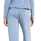 A person wearing the Eberjey EBJ Gisele Slouchy Set—soft, sustainable TENCEL™ Modal pajamas in loose-fitting, light blue long-sleeve top and matching pants—stands barefoot against a white background, shown from the back.