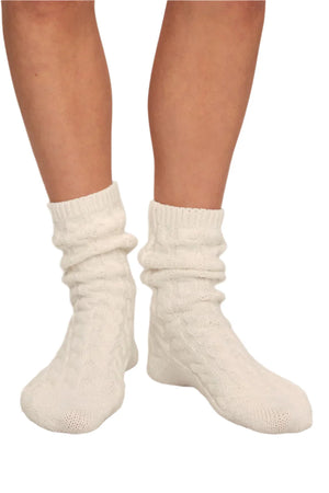 A person wearing the white Eberjey Cozy Socks, crafted from recycled polyester for a snug and comfortable fit with a cozy cable-knit design.