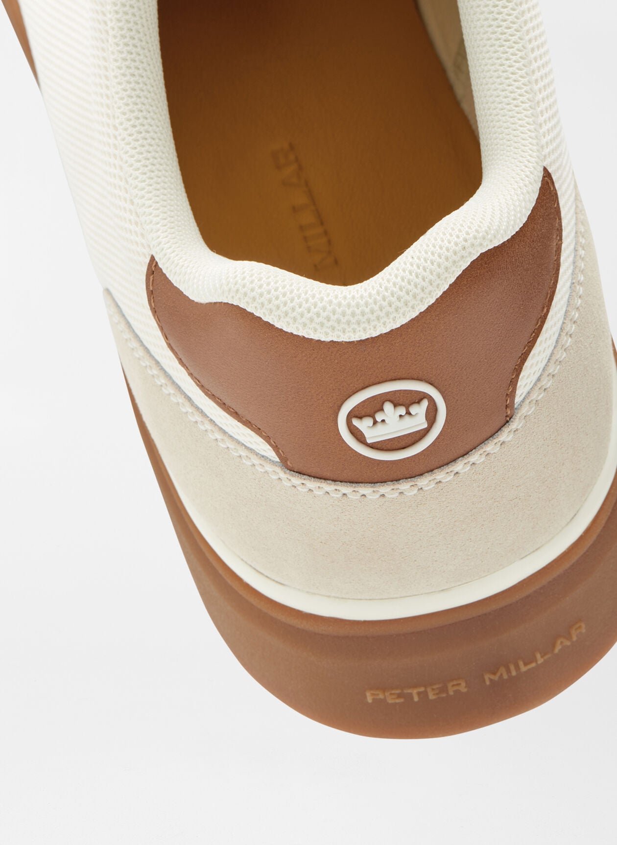 Close-up of the heel of the Peter Millar Drift Mesh Sneaker in brown and beige, featuring a crown logo, "Peter Millar" branding on the sole, and herringbone traction for grip.