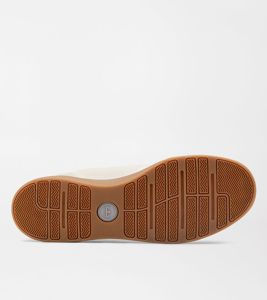 The Peter Millar Drift Mesh Sneaker features a brown rubber sole with a textured herringbone traction pattern and a circular logo at the center, shown against a white background.