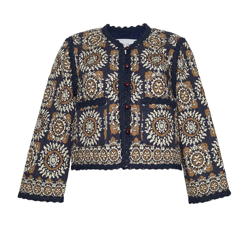 The Cara Cara Marissa Jacket by Cara Cara is a traditional long-sleeve piece featuring a navy, brown, and beige intricate floral pattern. It includes a front button closure, two front pockets, and exquisite jacquard ribbon detailing.