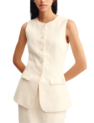 A woman wears POSSE’s sleeveless Matilda Gilet in off-white linen, tailored with two front pockets and a rounded hem, paired with a matching skirt.