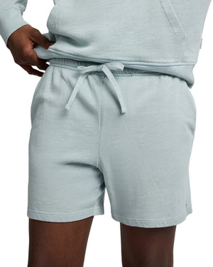 A person in Onia’s Slub Terry Short and matching hoodie, one hand on the waistband—an effortless lounge essential.