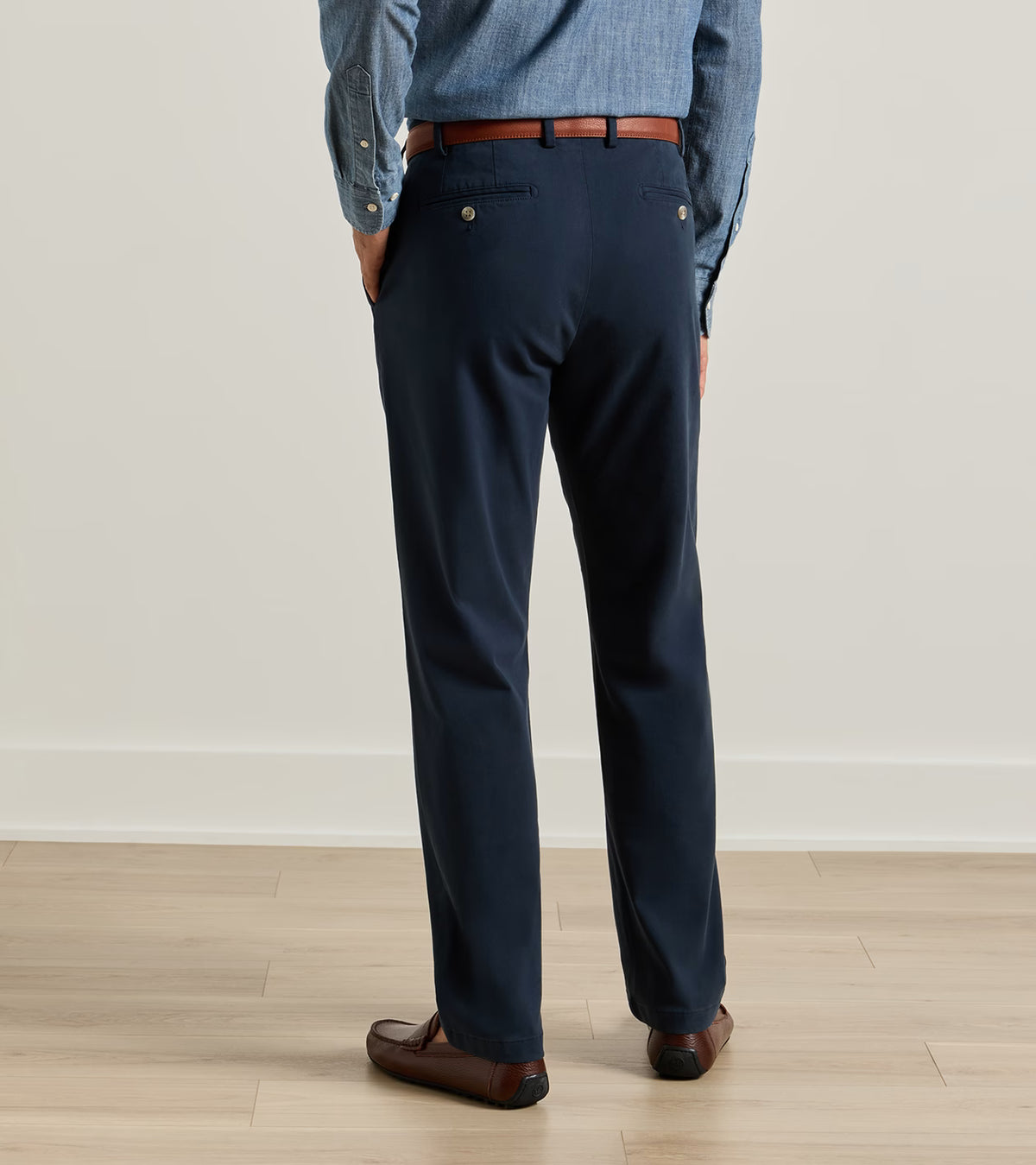 Back view of dark navy Signature Sateen Flat Front Trouser styled with a brown leather belt and loafers.