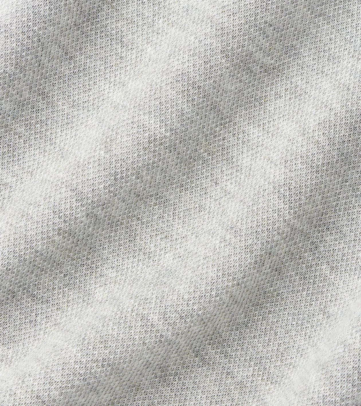 Close-up of the Crown Comfort Pullover by Peter Millar, showcasing its light grey, textured fabric with a subtle diagonal ribbed pattern. The material is soft and slightly heathered, delivering sweatshirt-like comfort—ideal for a lightweight layer or quarter-zip pullover.