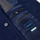 Close-up of the inside of a navy Excursionist Flex Blazer by Peter Millar, highlighting buttons, inner pockets, and a fabric label with the brand name.