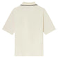 The Frame Light Pique Polo is a short-sleeved, off-white cotton shirt shown from the back, featuring a black double stripe on the collar.