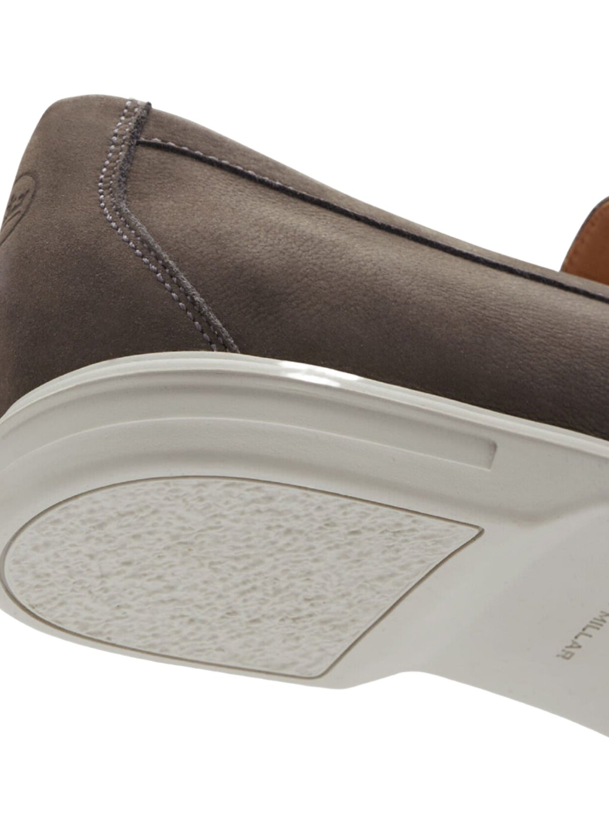 Close-up of the sole and heel of a dark brown Peter Millar Excursionist Venetian Loafer featuring white stitching and an emblem on the rear. The white sole has a textured grip on the heel, highlighting its lightweight versatility.