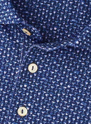 Close-up of the Peter Millar Sidecar Performance Jersey Polo in blue, featuring a small white cocktail glass pattern, gold-colored buttons, and four-way stretch fabric for maximum comfort.