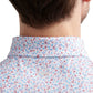 Close-up of the back of a person's neck and shoulders, wearing a Peter Millar Orange Crush Performance Jersey Polo with UPF 50+ protection.