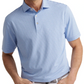 A man wears a light blue and white striped Lenway Performance Jersey Polo by Peter Millar, featuring UPF 50+ and four-way stretch, paired with white pants and his hands in his pockets.