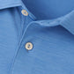 Close-up of the Peter Millar Featherweight Mélange Performance Polo in light blue, highlighting the top portion with two white buttons and its textured performance fabric pattern.