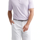 A man wearing the Peter Millar Featherweight Payne Stripe Performance Polo, a gray belt, and white shorts stands with one hand in his pocket against a plain background.