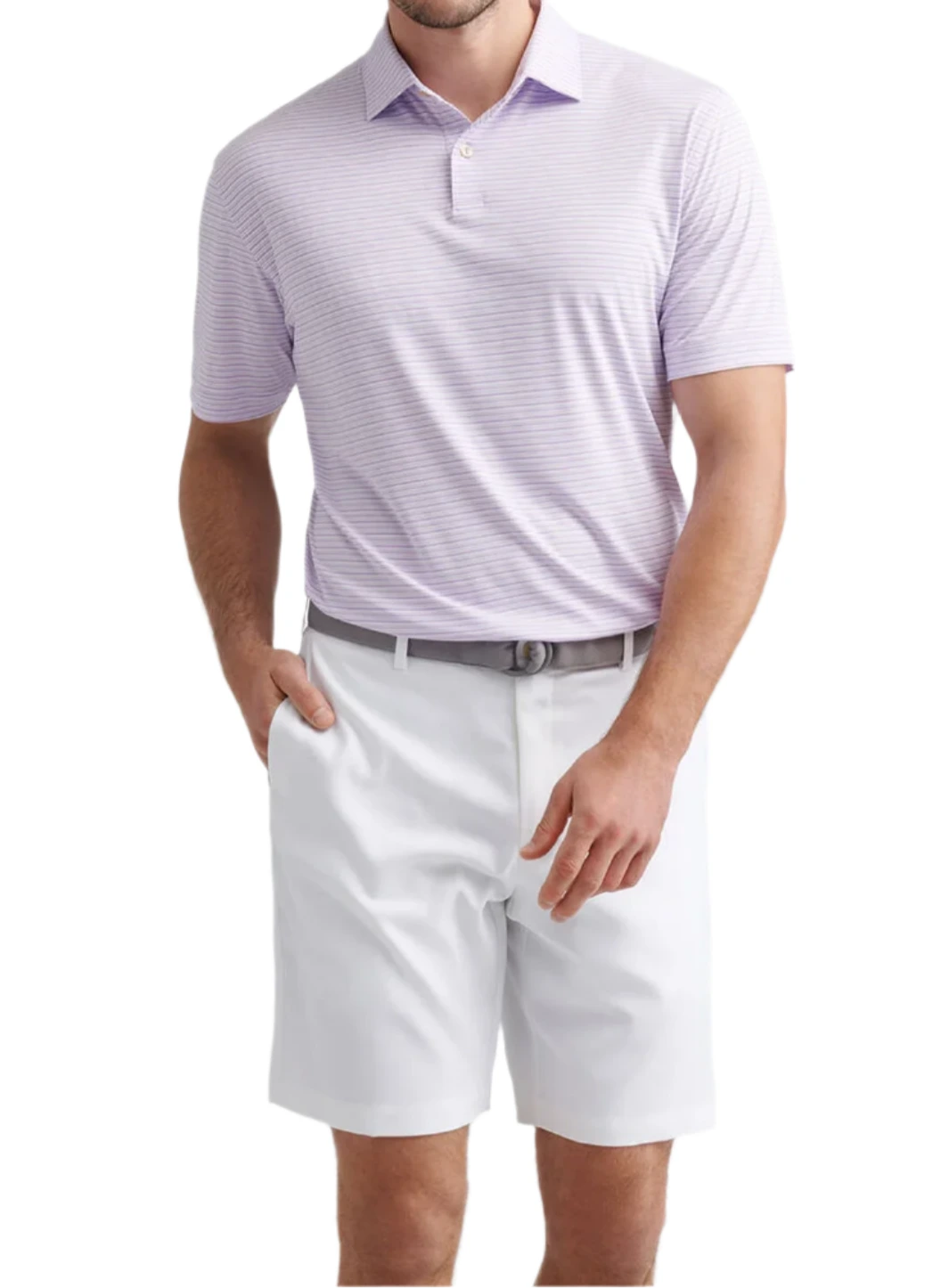 A man wearing the Peter Millar Orange Crush Performance Jersey Polo with four-way stretch and UPF 50+, paired with white shorts and a gray belt, stands with one hand in his pocket against a white background.