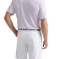 A man stands facing away, wearing the Peter Millar Featherweight Payne Stripe Performance Polo in light purple, paired with white shorts featuring belt loops and a grey belt.