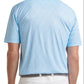 A man is seen from the back wearing the Peter Millar Featherweight Pineapple Mosaic Performance Polo in light blue, featuring a small repeating pattern and lightweight fabric, paired with white pants.