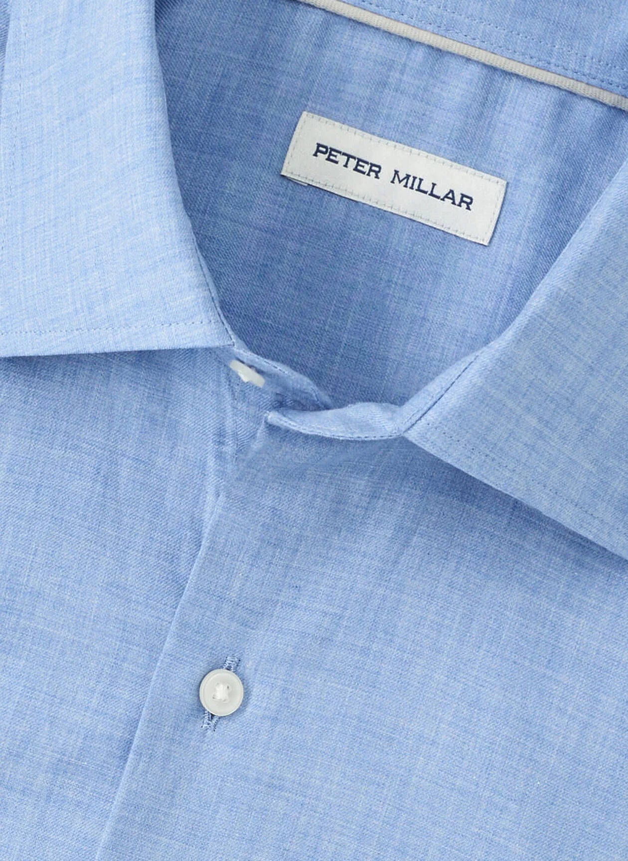 Close-up of a light blue Peter Millar Highlands Soft Twill Cotton Sport Shirt, featuring a spread collar, top button, and brand label.