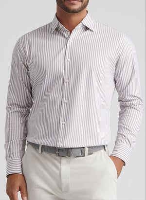 A man wearing the Peter Millar Cannon Crown Lite Cotton-Stretch Sport Shirt—this long-sleeve, button-up features vertical beige and white stripes and easy-care fabric, paired with light pants and a patterned belt for effortless style.