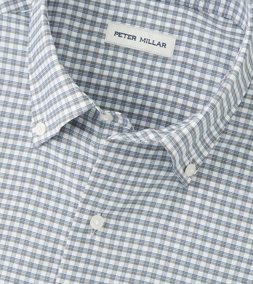 A close-up of a blue and white checkered Cashiers Performance Twill Sport Shirt by Peter Millar, featuring the brand’s label inside the collar.