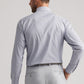 A man stands with his back to the camera, wearing a Peter Millar Cashiers Performance Twill Sport Shirt in light blue check, tucked into light grey dress pants. This moisture-wicking shirt blends comfort and style for any occasion.