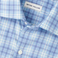 Close-up of the Peter Millar Bar Harbor Performance Flannel Sport Shirt in light blue and white plaid, featuring a button-up front and soft performance fibers, with the "Peter Millar" label sewn inside the collar.