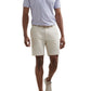 A man wearing a light purple striped polo shirt, Peter Millar Bingham Performance Shorts, a beige belt, and light-colored sneakers.