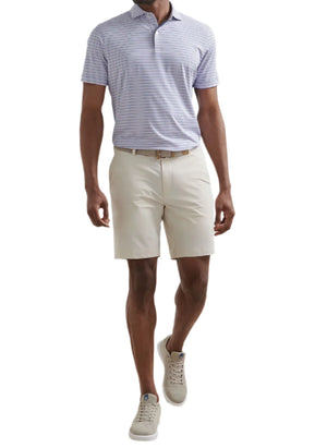A man wearing a light purple striped polo shirt, Peter Millar Bingham Performance Shorts, a beige belt, and light-colored sneakers.