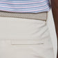 A person wearing a blue and pink striped shirt tucked into light beige Bingham Performance Shorts by Peter Millar, styled with a braided beige belt.