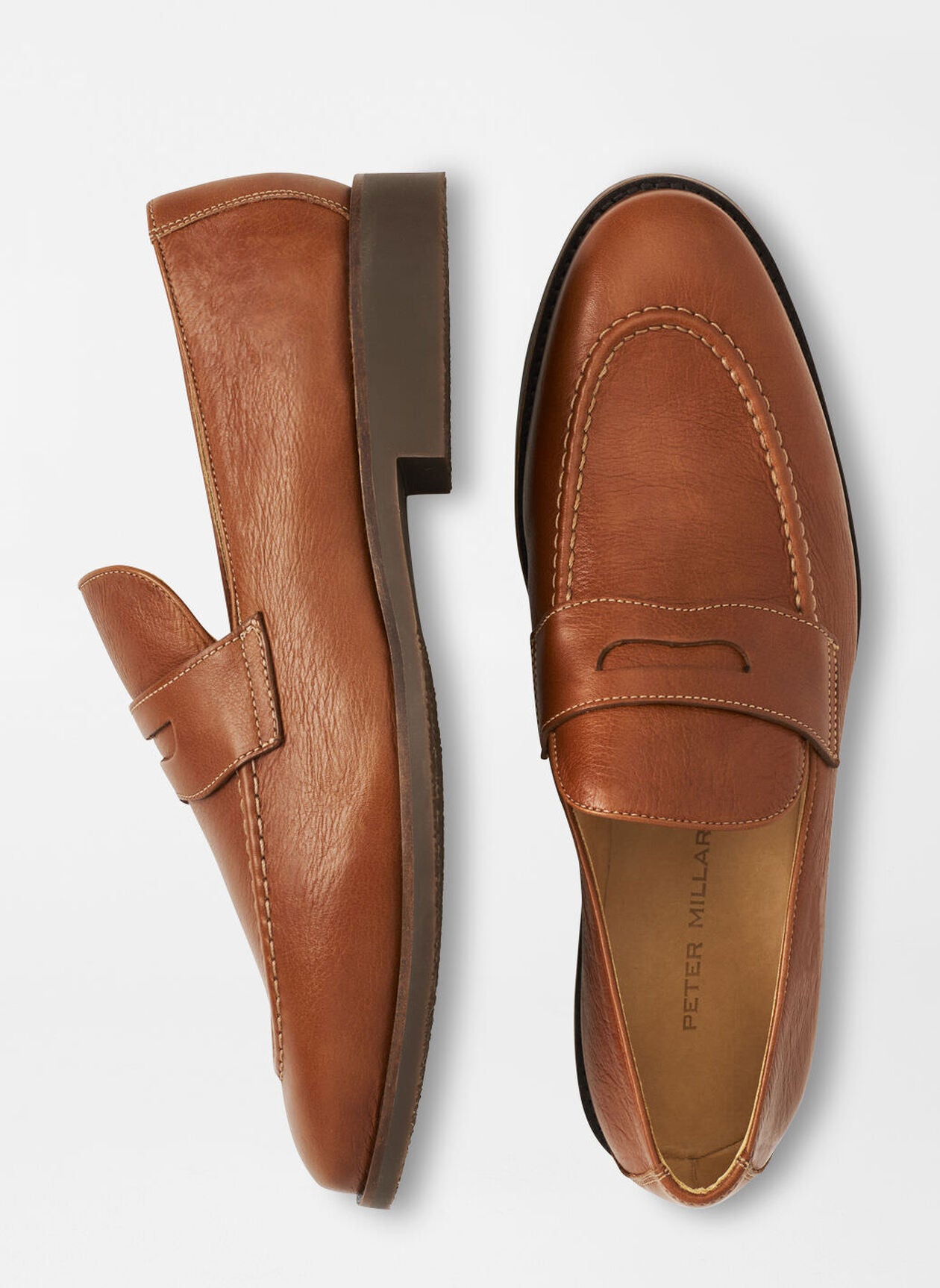 The Peter Millar Madison Penny Loafer is a pair of brown modern shoes crafted from tumbled calf leather with stitching details and flat soles, shown from top and side views.