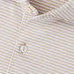 Close-up of the Peter Millar Ballad Performance Jersey Polo, a beige and white striped collared shirt with two white buttons, crafted from soft jersey fabric for four-way stretch comfort.