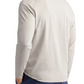 A man shown from the back with hands in his pockets wears the Peter Millar Stealth Performance Quarter-Zip, a lightweight pullover featuring UPF 50+ sun protection, paired with dark blue pants.