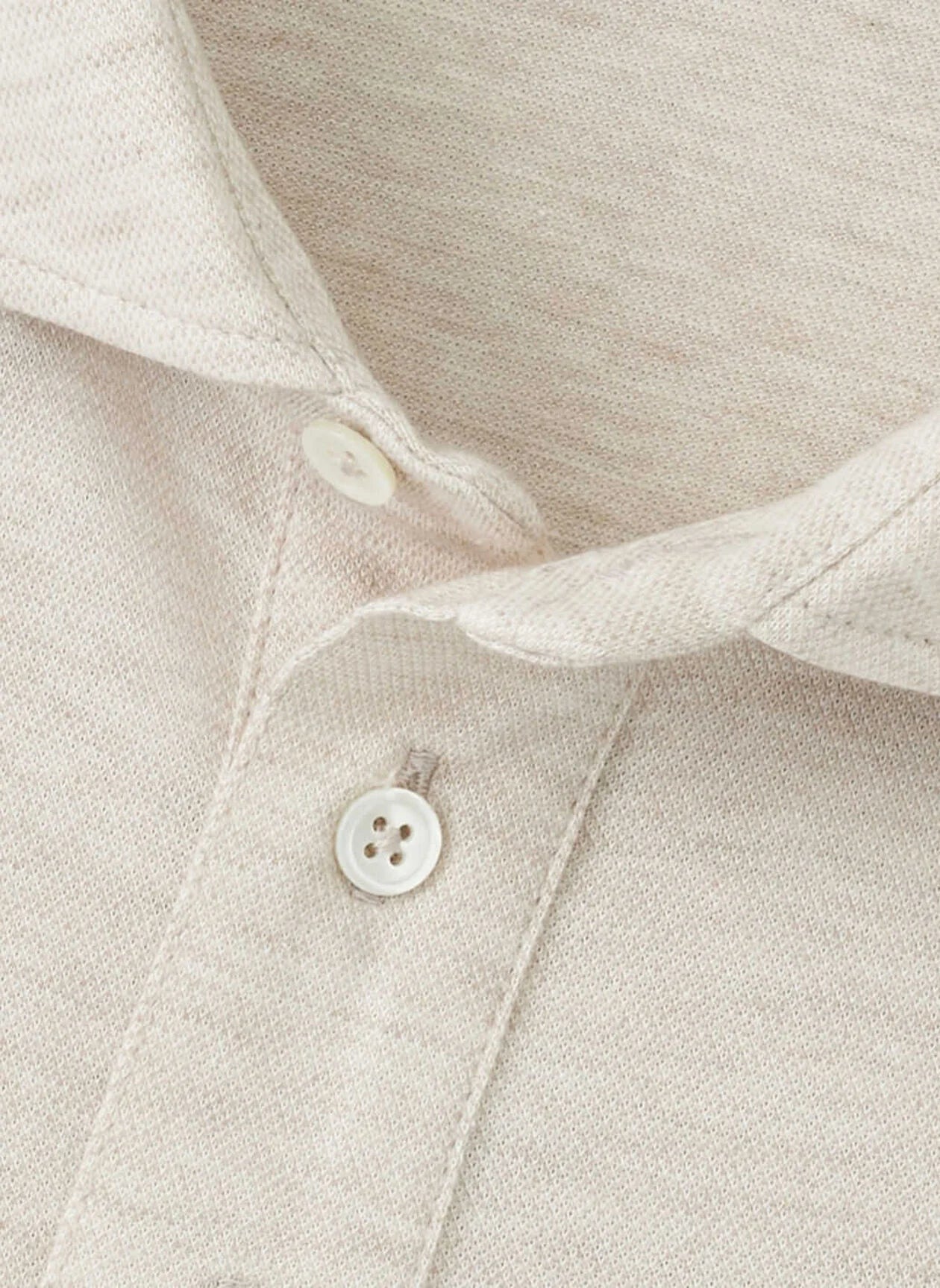 Close-up of the Peter Millar Amble Long-Sleeve Cotton Cashmere Polo in beige, featuring a collared design with two white placket buttons that highlight the fabric's texture and stitching details.