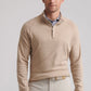 A man stands facing the camera against a plain background, wearing the Peter Millar Grant Birdseye Quarter-Zip sweater over a collared shirt and light-colored pants.