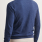A man wearing a Peter Millar Excursionist Flex Full-Zip Sweater in blue and light beige pants is shown from the back, facing slightly left against a plain background.