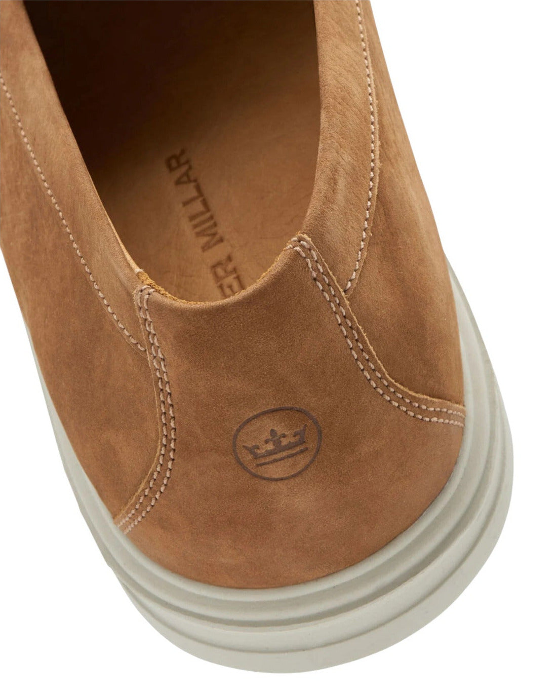 Close-up of the Excursionist Nubuck Venetian Loafer by Peter Millar: tan water-resistant nubuck, white stitching, crown logo on the heel, "PETER MILLAR" on the insole, and a white rubber sole offer lightweight versatility.