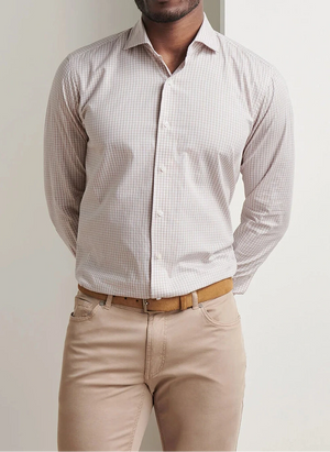 A man stands against a white background wearing a Peter Millar Torino Cotton Sport Shirt in a light checkered pattern, paired with beige pants and a tan belt.