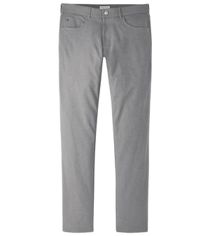 The Peter Millar eb66 Melange Performance Five-Pocket Pant 30″ is a pair of light gray straight-leg pants made from stretch twill fabric, designed with front and back pockets, belt loops, a button closure, and a comfort waistband, shown against a white background.