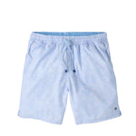 The Peter Millar Shoreline Rays Swim Trunk, shown on a white background, is a light blue men's swim trunk with a subtle geometric pattern. It features an elastic drawstring waistband, quick-drying fabric, mesh liner, and side pockets.