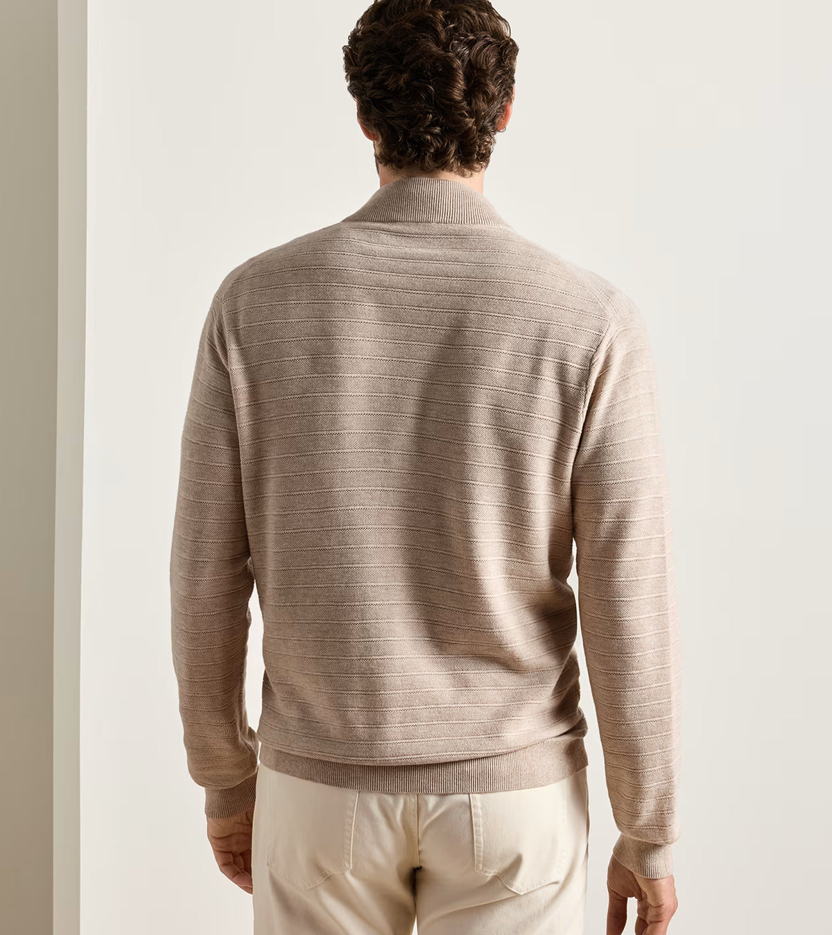 A man seen from the back wearing a lightweight, ribbed-knit, full-zip Pacific Full Zip Sweater by Peter Millar.