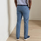 Back view of a person wearing blue Peter Millar Surge Performance Trouser, a striped shirt, and blue sneakers.