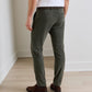 Rear view of a person wearing olive green Bingham Corduroy Performance Trouser, a white shirt, and dark brown suede boots.