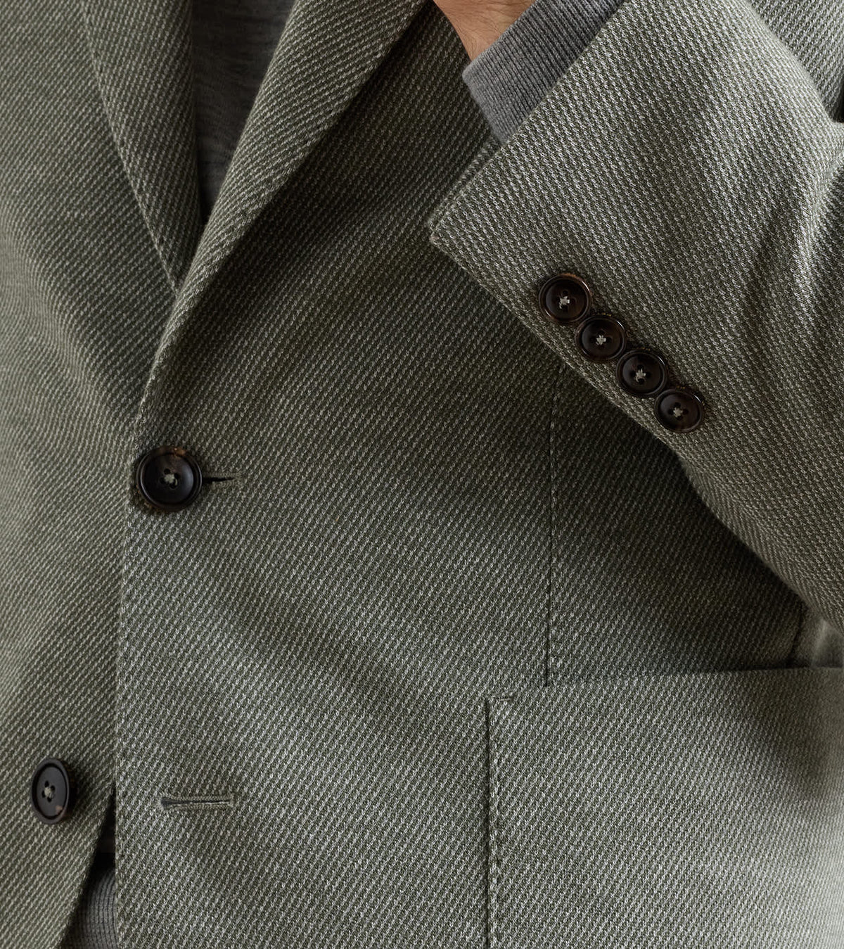 Peter Millar Barclay Knit Soft Jacket in olive green with a textured weave, two dark front buttons, and four small cuff buttons.