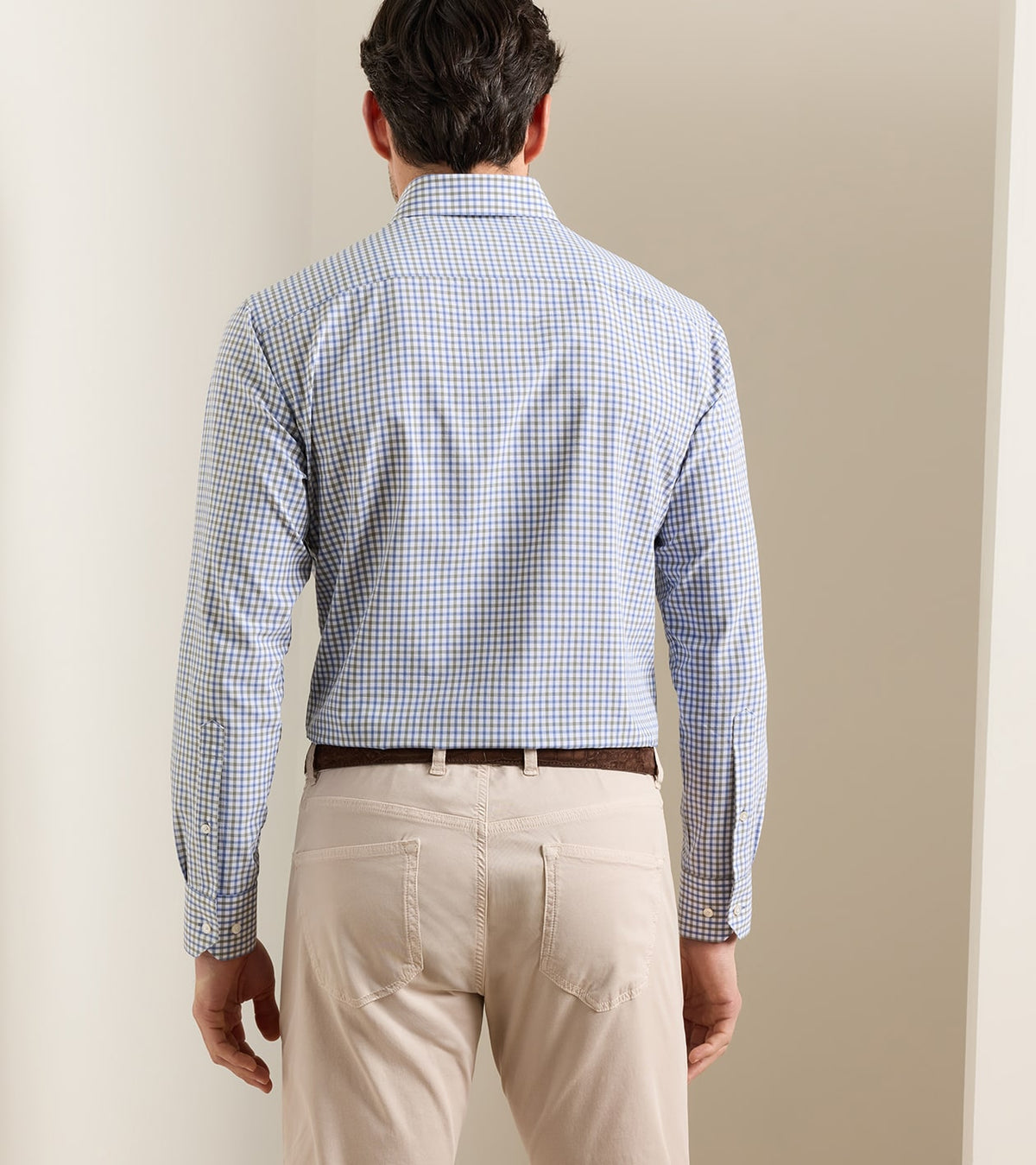 Back view of a person wearing a blue and white checkered Clarence Performance Poplin Sport Shirt tucked into beige pants with a brown belt.