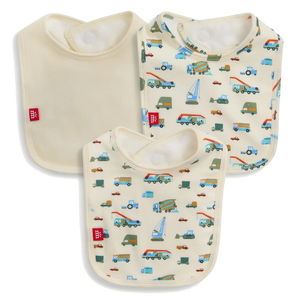 The Magnetic Me Dumps Like A Truck Modal Bib 3-Pack includes one solid cream and two vehicle-patterned bibs (cars, trucks, buses), all with white trim and red logo tags. Made from soft, eco-friendly modal for baby's comfort.