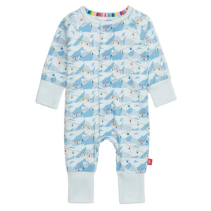 The Magnetic Me Baby Apres Chic Modal Convertible Coverall features a light blue mountain and skier pattern, sustainable modal fabric, light blue cuffs, multicolor stripe collar lining, and easy magnetic closures.