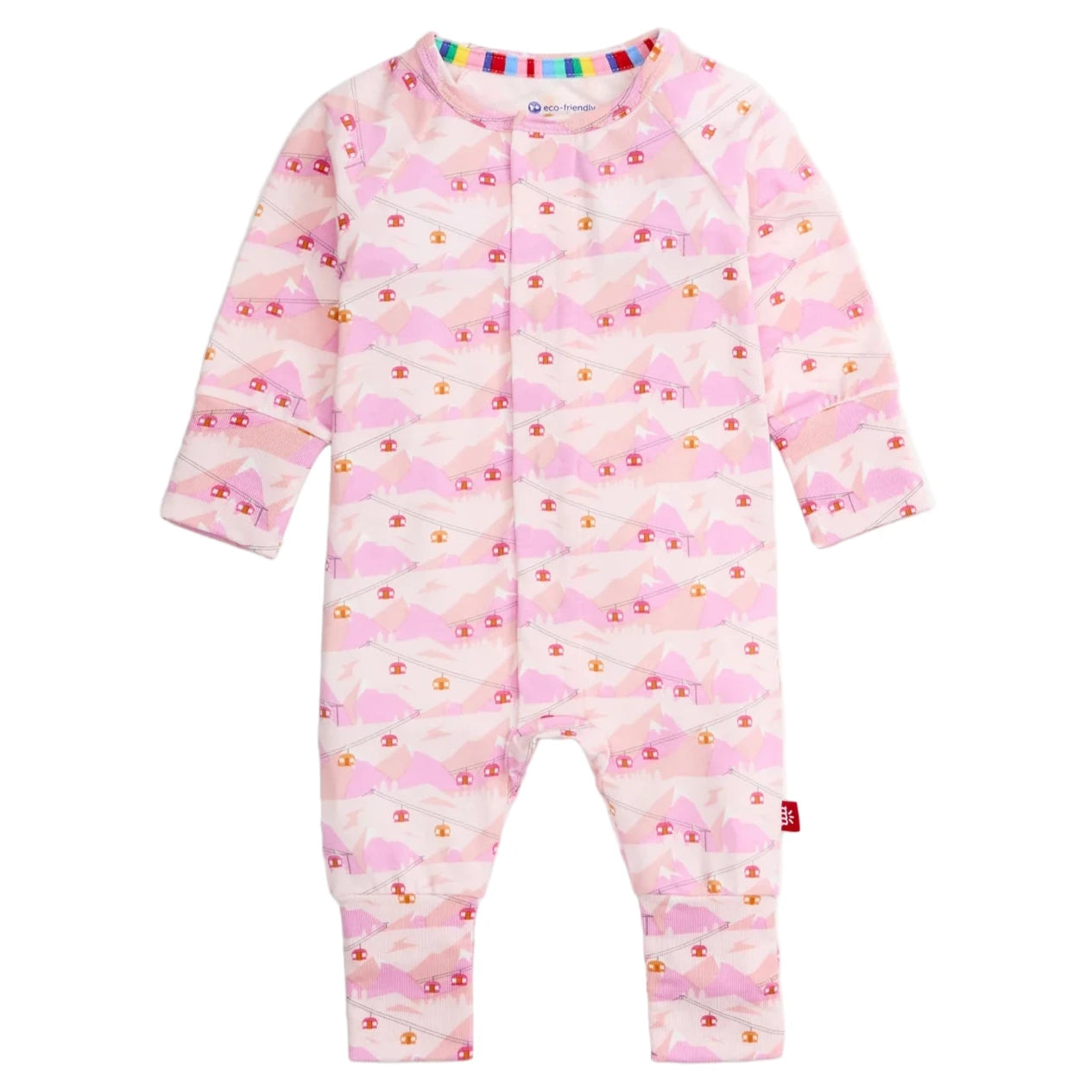 The Magnetic Me Baby Apres Chic Modal Convertible Coverall is a pink long-sleeve onesie with a mountain and cottage pattern, front snap closures, and rainbow-trimmed collar.