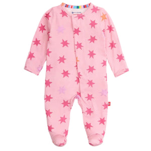The Magnetic Me Baby Girls' Cosmic Confetti with Foil Modal Footie is a pink long-sleeve onesie with covered feet, red and purple star pattern, and magnetic closures for quick changes.