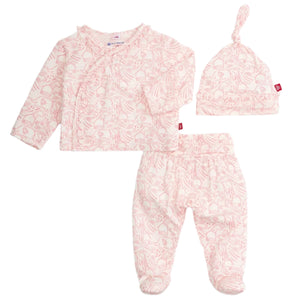 The Magnetic Me Baby Modal Kimono Take Me Home Set features a kimono wrap top, footed pants, and a knotted hat in pink and white animal print, all crafted from soft sustainable modal.